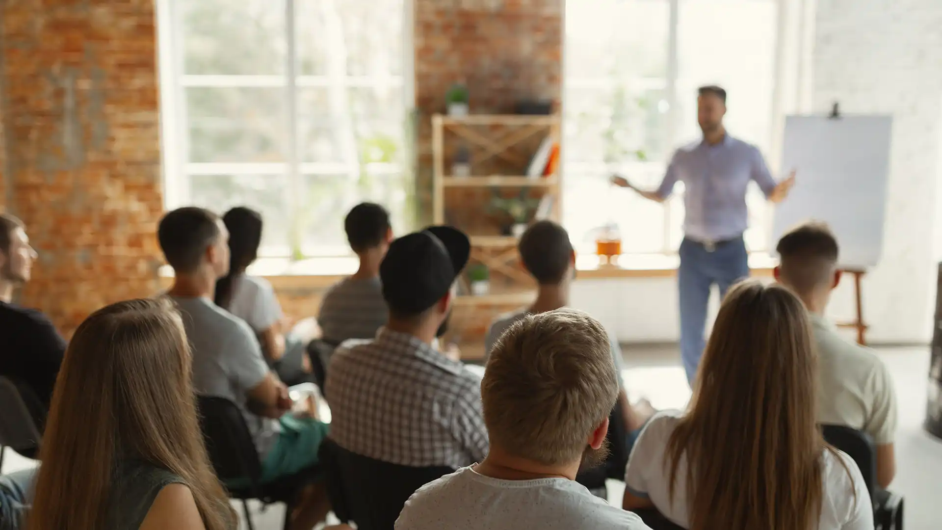 Ein Dozent trägt den Teilnehmern eines Seminars etwas vor