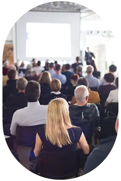 Workshop-Teilnehmer in einem großen Saal vor einer Leinwand