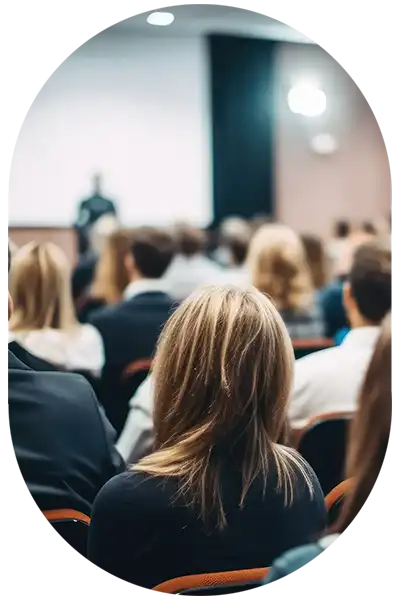 Ein großer, gut gefüllter Veranstaltungsraum mit Redner vor Leinwand.