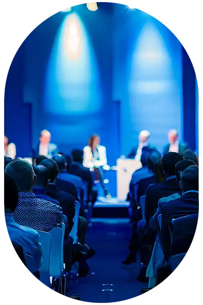 Podiumsdiskussion mit Publikum in blau ausgeleuchtetem Raum